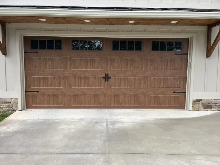 Completed Blackstone installation with a brown double garage door and decorative hardware