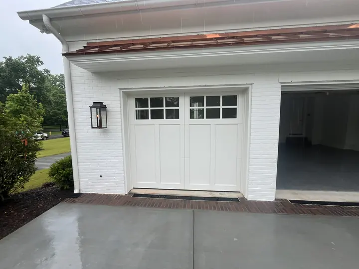 Completed Blackstone installation with a white sectional garage door and rectangular upper windows