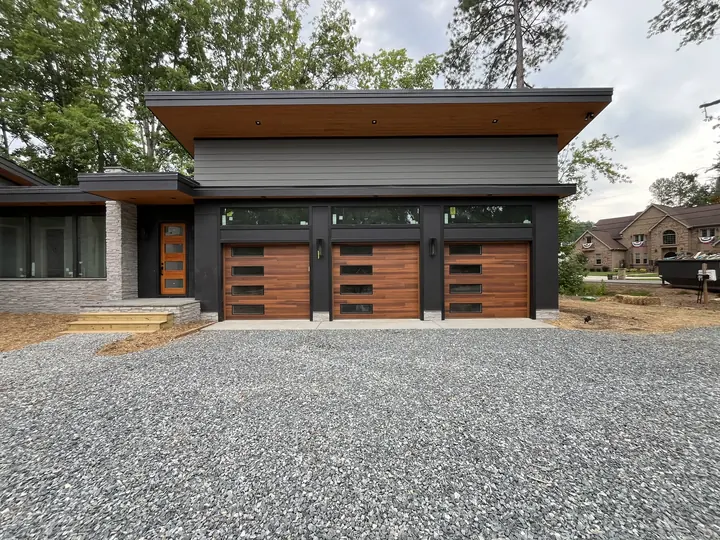 Completed Blackstone Wooden Garage Door installation with dark wood-toned double doors on a single-story exterior