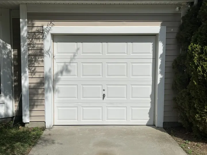 Completed Blackstone installation with a white garage door and decorative black hardware
