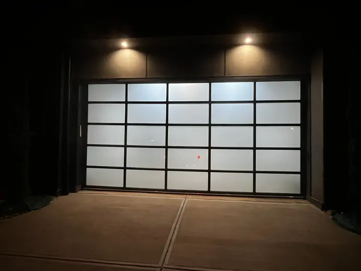 Completed Blackstone Glass Garage Door installation with frosted panels in a black frame