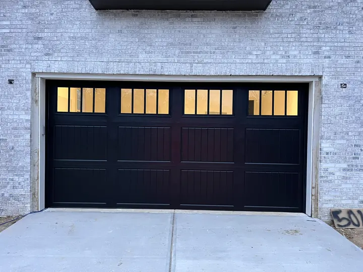 Completed Blackstone installation with a black garage door and square upper windows